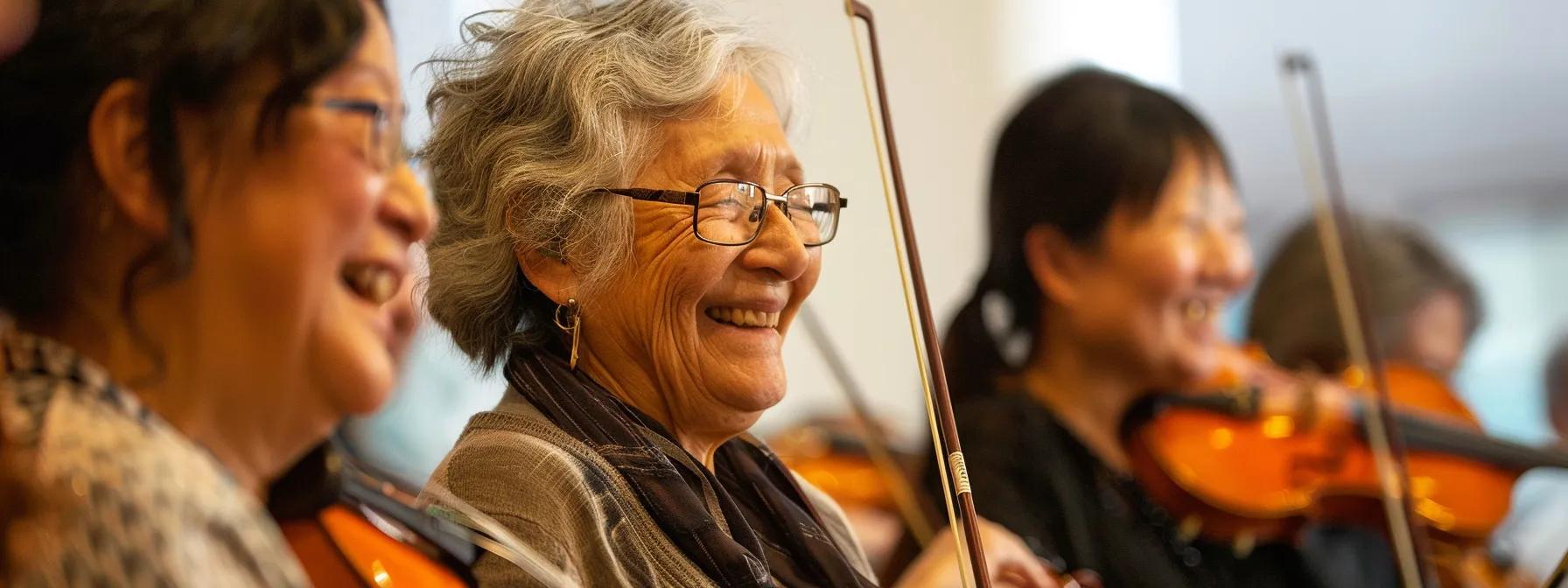 Musicians of various ages smiling and interacting during a lively community orchestra rehearsal.