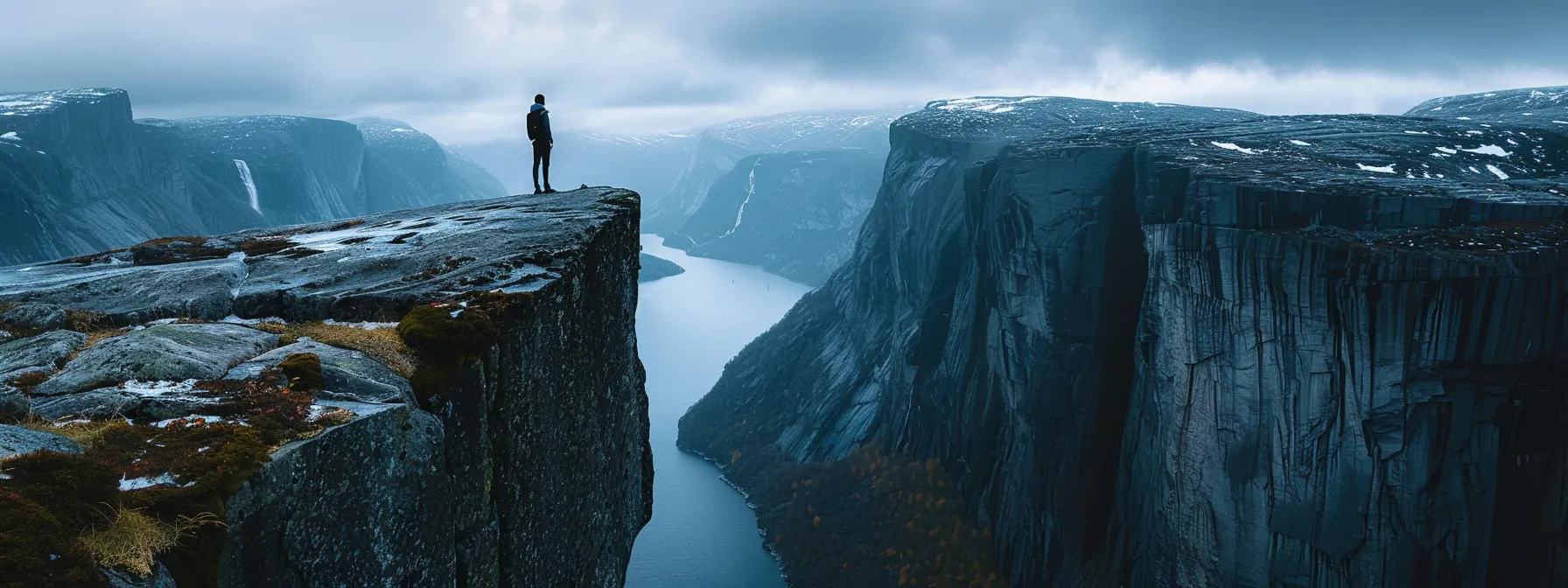 a person standing on a rocky cliff, gazing out at a vast and dynamic landscape, symbolizing the need for adaptability and foresight in seo strategy.