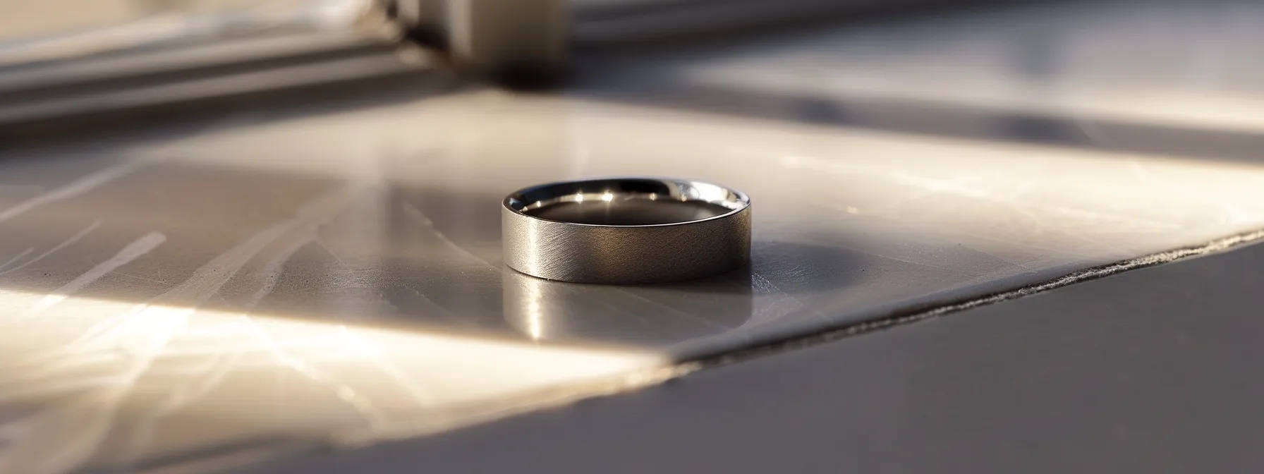 a sleek titanium wedding ring with a simple design and a subtle engraving, resting on a clean, modern surface.