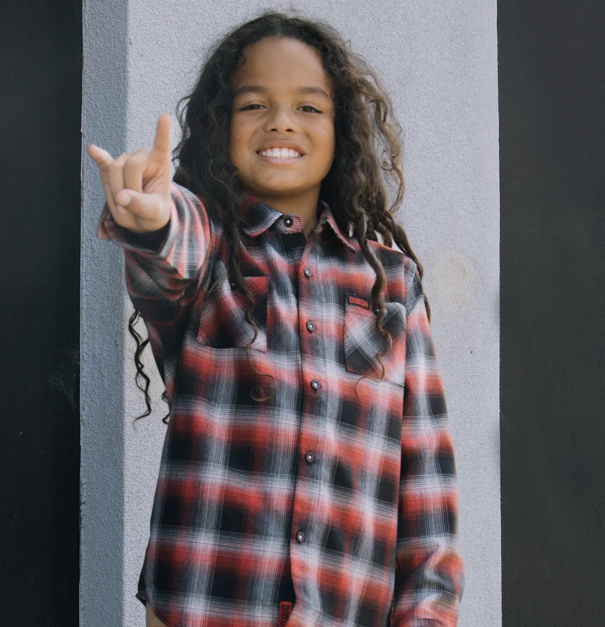 Young boy making the rock and roll symbol with his hands and wearing the In Flames Lunar Strain Flannel