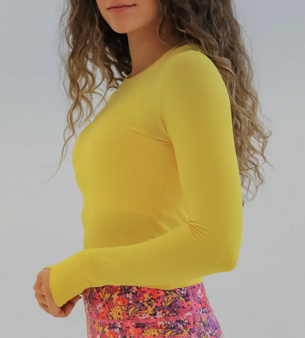 Close up side view of woman wearing bright yellow top from Seamless Collection
