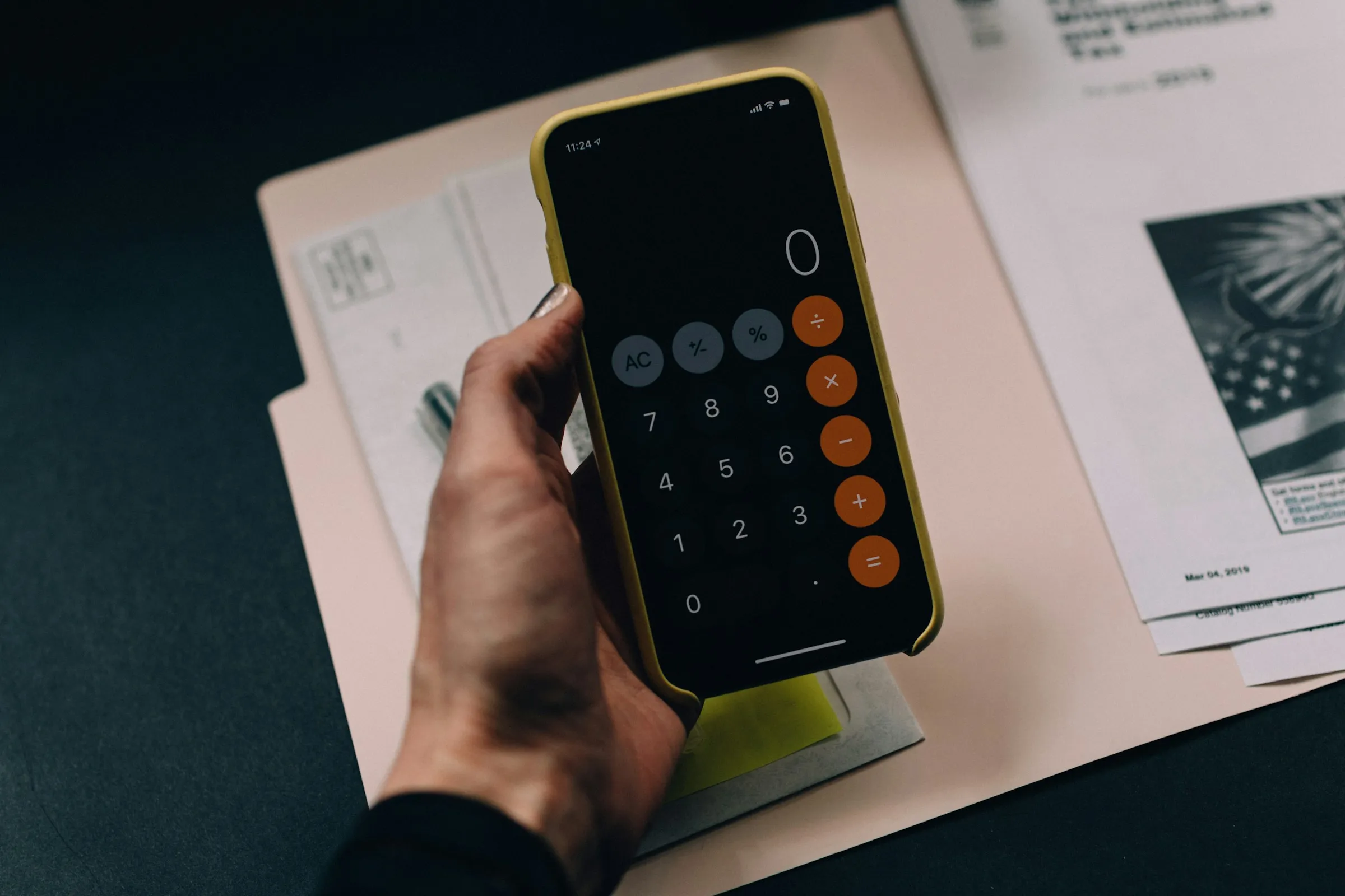 A person holding a smartphone with a calculator app open A person holding a smartphone with a calculator app open