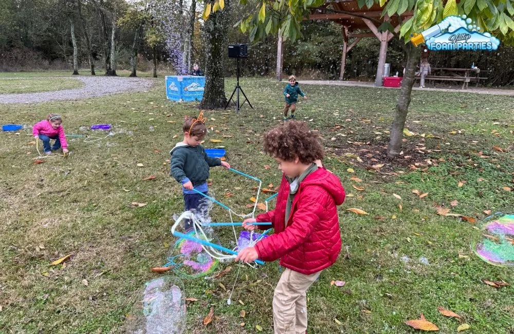 Children playing in a cloud of bubbles during daytime and nighttime bubble parties by hilltop foam parties.
