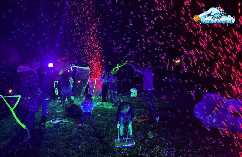Bubble parties: participants are using neon-colored wands and strings to create massive, elongated bubbles that stretch across the grass.