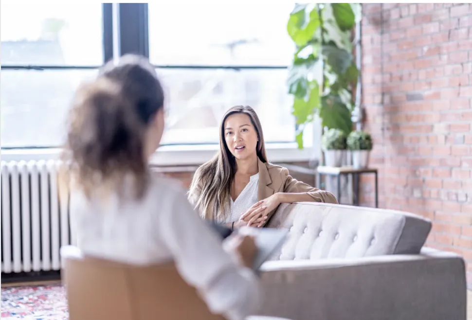White female discussing mental-health care options with a clinician at a VA facility.