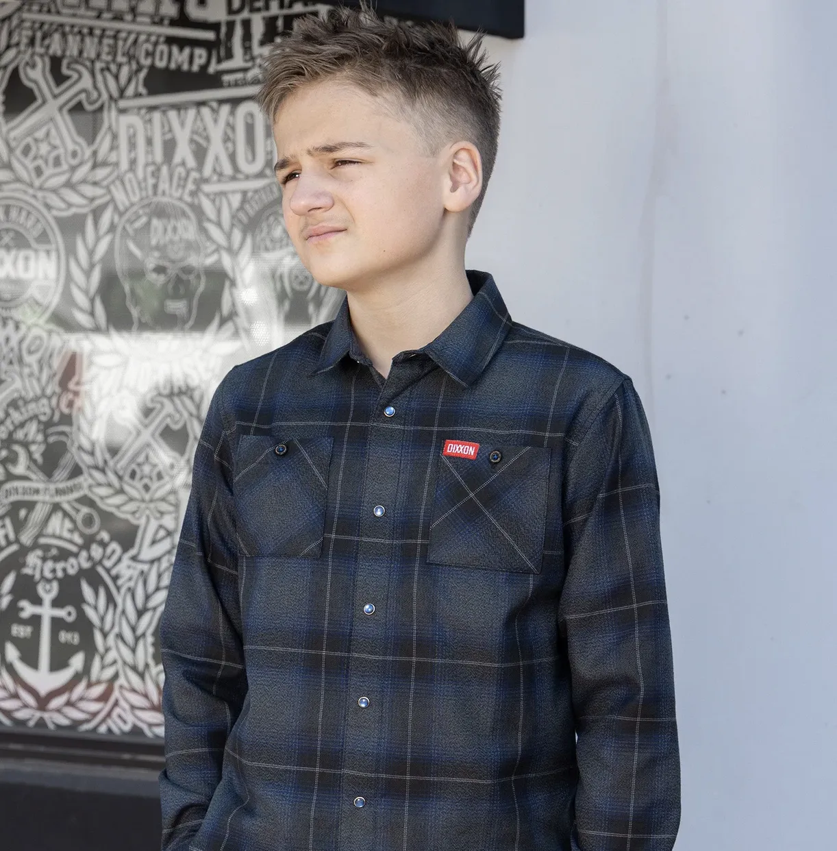 Boy in front of black and white background wearing Dixxon Youth Benchmark Flannel