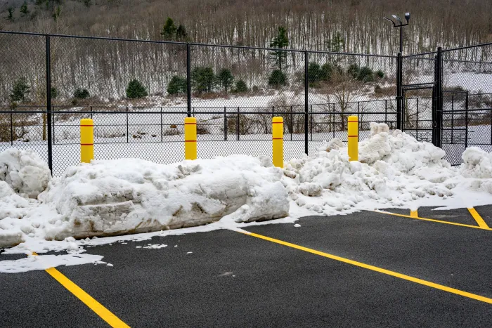 Snow plow clearing a parking lot in Clarence, NY — reliable snow plowing and salting services.
