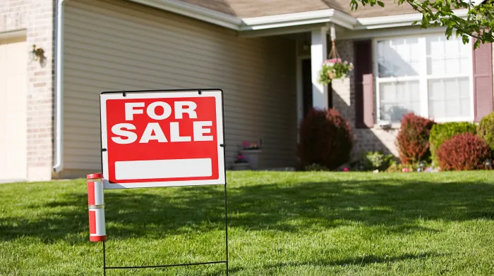 House exterior with 'For Sale' sign symbolizing quick cash sale options for homes with liens