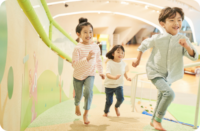 체력이 넘치는 아이 세 명이 실내에서 뛰어노는 모습