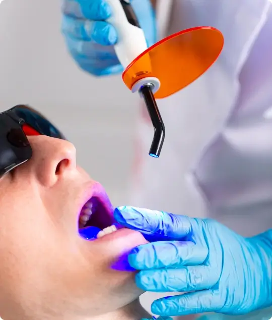 A dentist performing a laser deep cleaning procedure using advanced light energy to precisely target bacteria for a more comfortable experience.