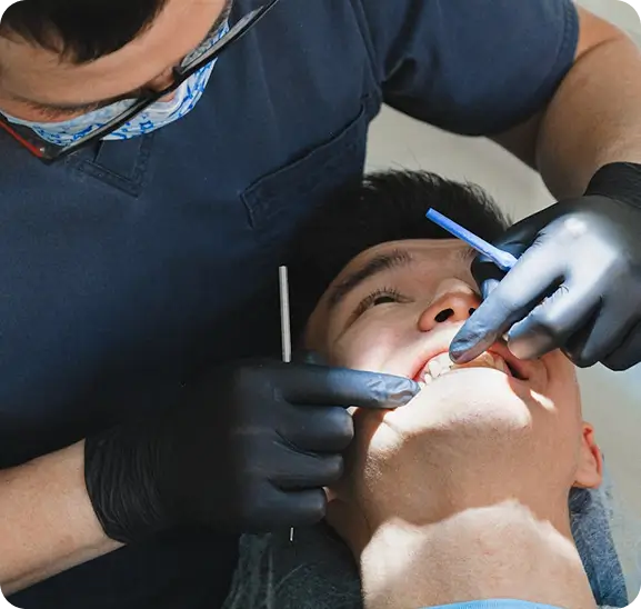 A skilled dental team at Issa Dental performing a root canal retreatment to remove recurring infection and restore the health of a previously treated tooth.