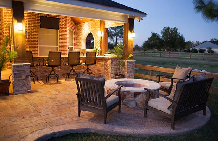 Paved outdoor patio with seating and an outdoor kitchen