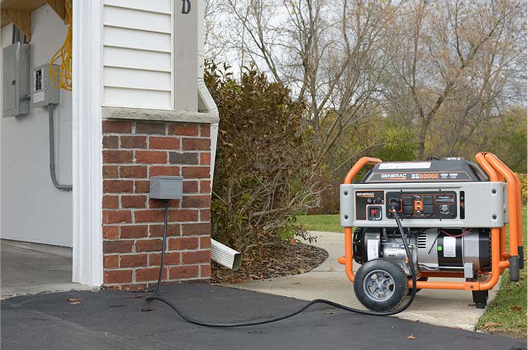 Portable generator on a driveway outside a house