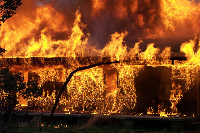 Flames consuming a building at night