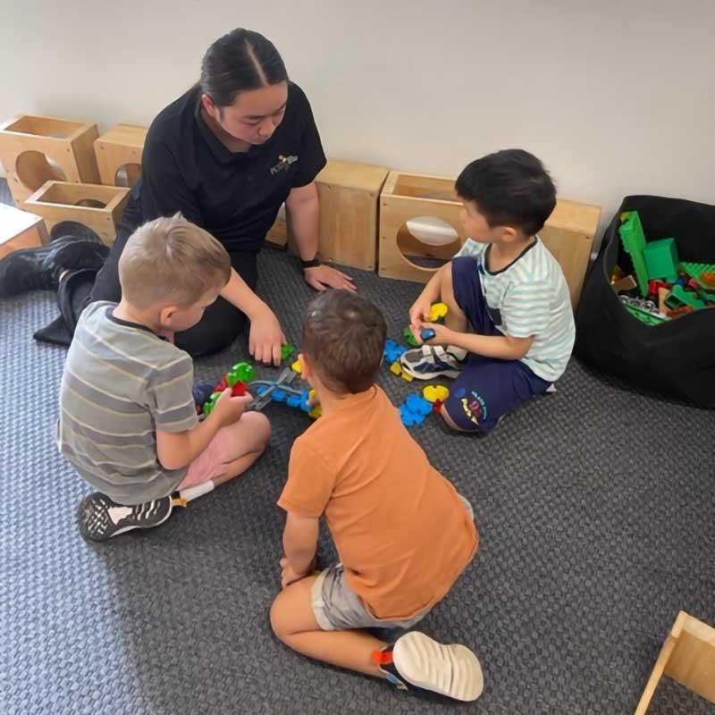 Anna Lam, our Exceptional Team Member for January 2023 sits and interacts with three children within her studio at Petit ELJ Richmond.