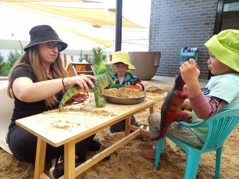 An Educator sits with children learning about her self development as she interacts with children.