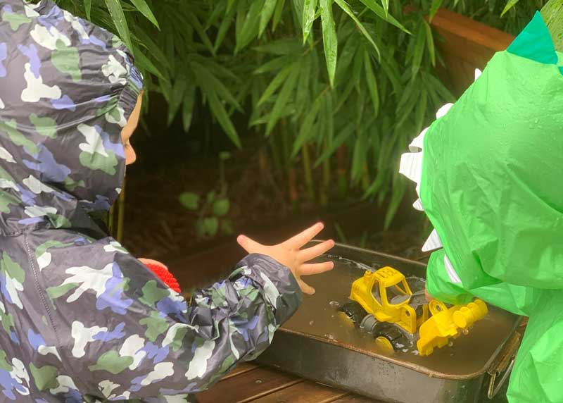 Children play outside in the rain a "natural" nature play resource.