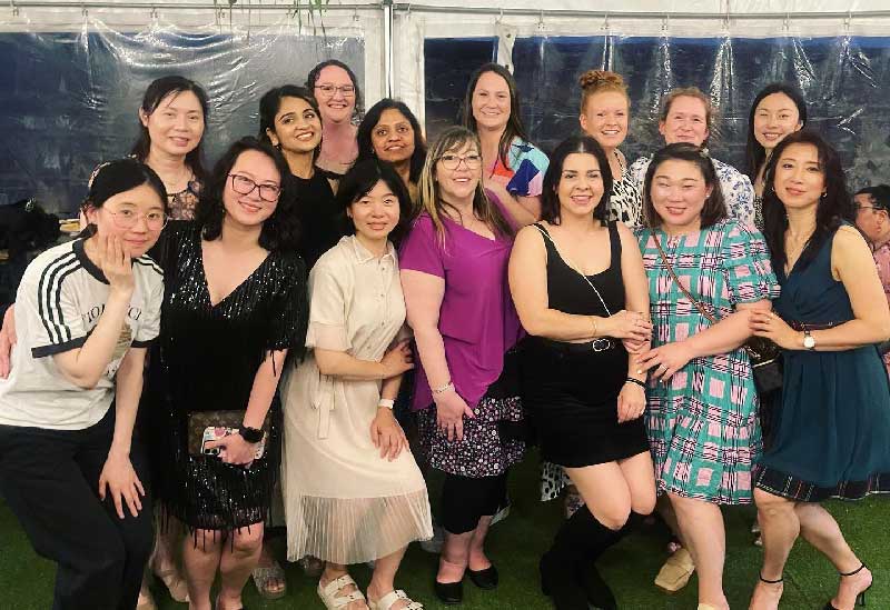 A group of Early childhood professionals from our Petit Early Learning Journey Forest Hill centre gather for a photo at their awards night celebrating their dedication and engagement. Seven educators in the front row, bend slightly to reveal eight peers standing behind them. Everyone is smiling.