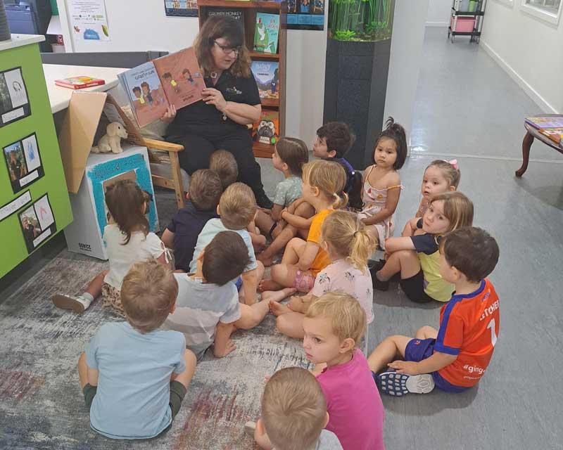  Joanne sits and reads to a group of children and reflects on becoming an educator.