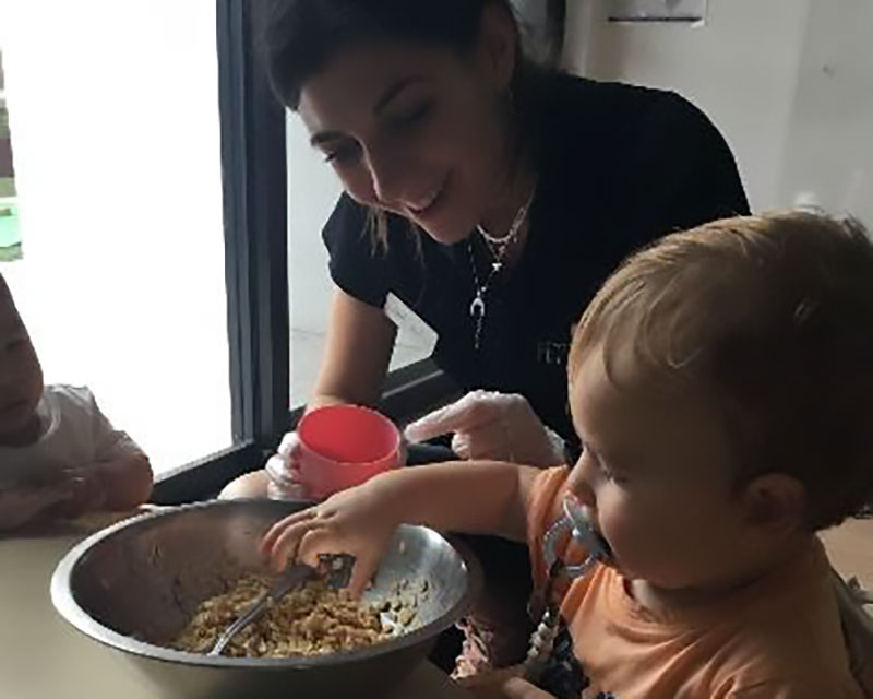 Educator encourages a child to explore their sensors through cooking.