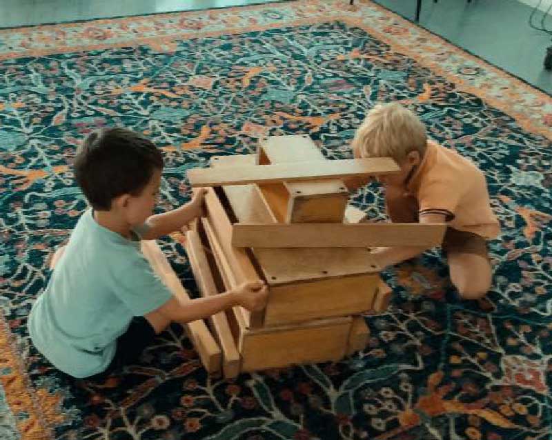 Loose parts play ideas can include wooden planks and blocks that children can move about, stack, unstack, reorganise.