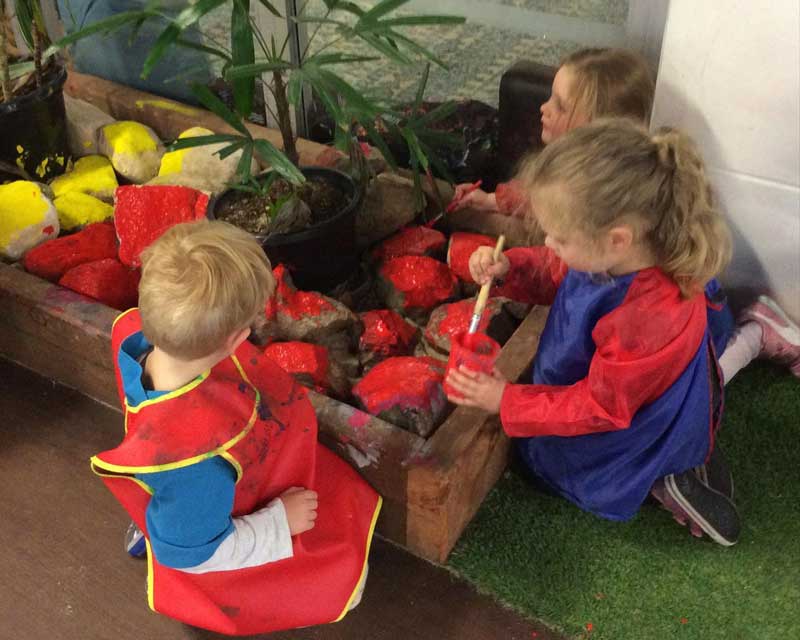 Children at Petit ELJ Barton paint rocks for National Reconciliation Week.