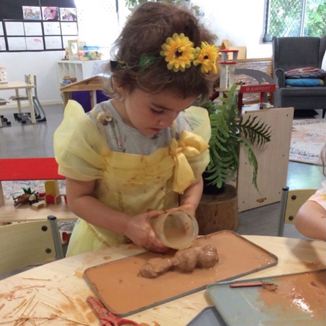 Child learns through active hands on investigation at Petit Early Learning Journey