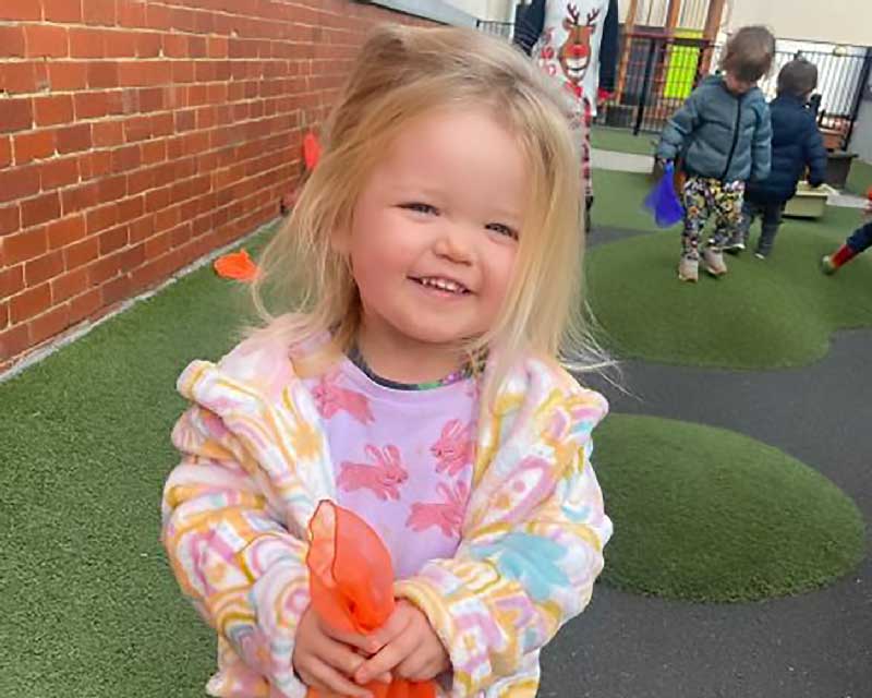 A happy child holds an orange scarf to show and understand feelings.. 