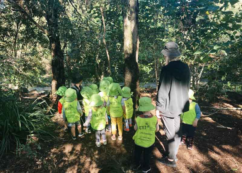 Children from Petit ELJ gather in the bush to enjoy nature play benefits.