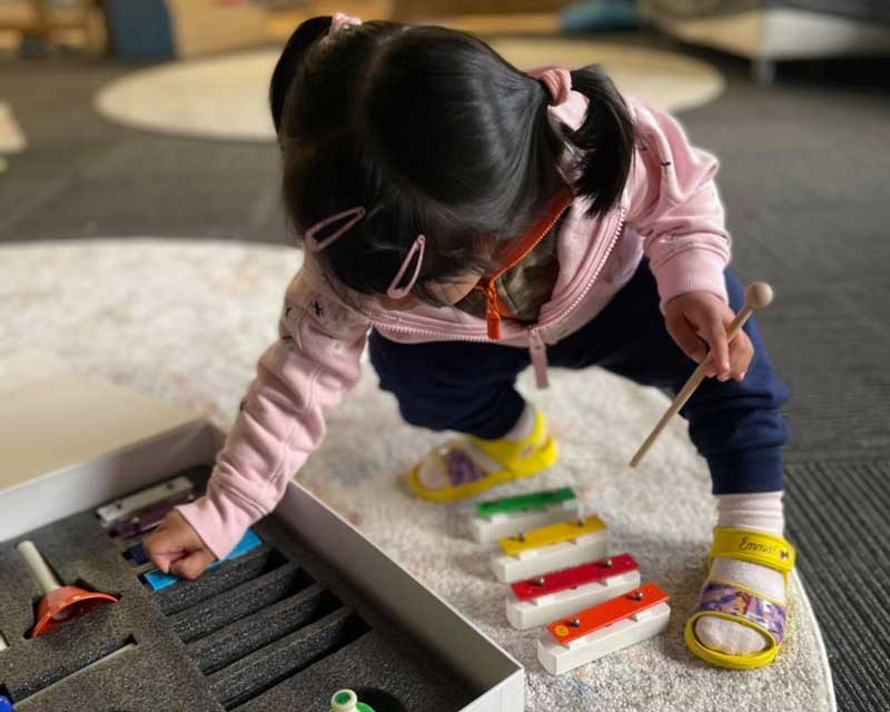 A child assembles their own musical instrument benefitting from music and movement for children.