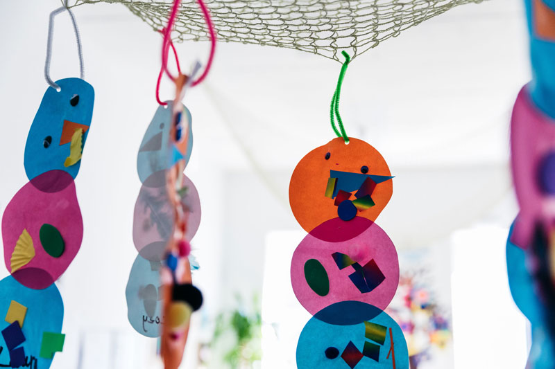 Creative inquiries and art displays that hang from the room's ceiling help to make children's learning visible.