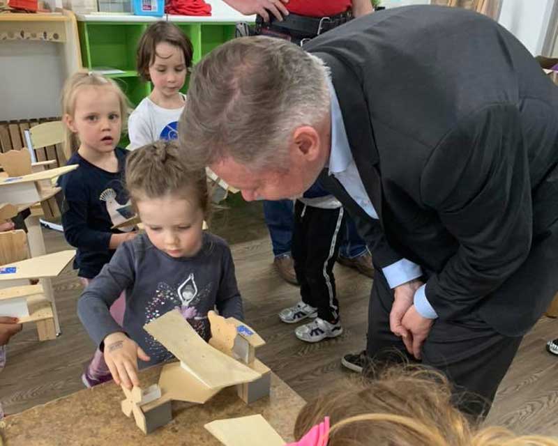 Dad inspects child's woodworking project - a creative activity when at home on Father's Day.