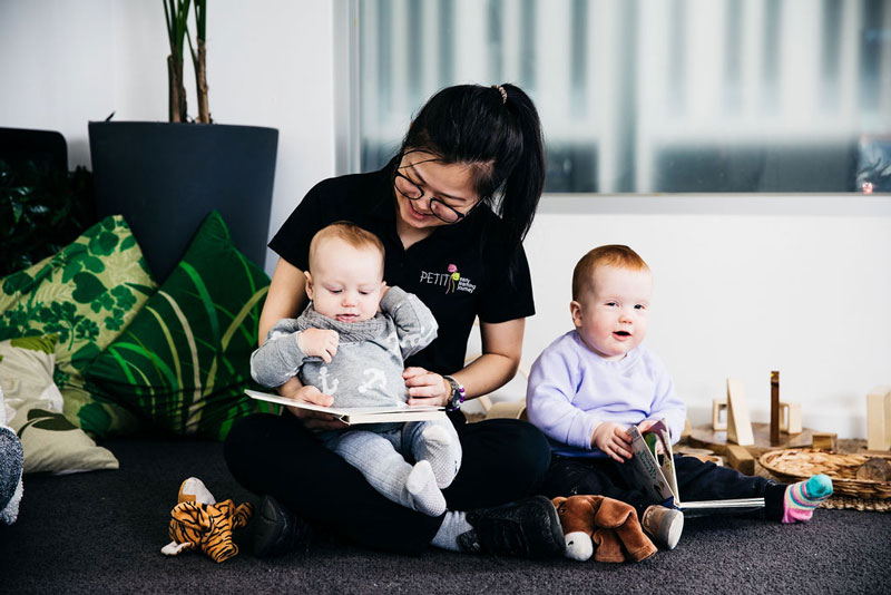 A float Educator reads to children - part of their day in an early learning centre.