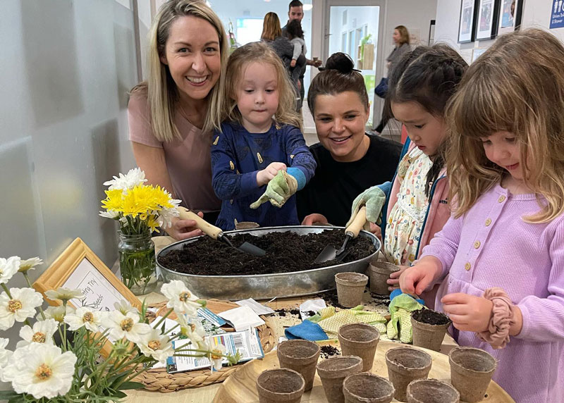 Mums with children making homemade Mother's Day gift ideas.