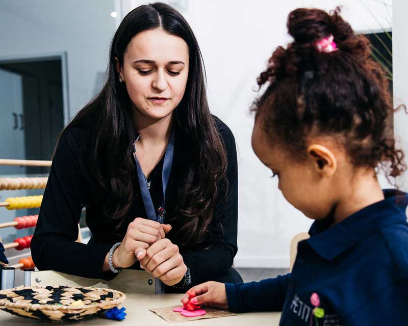 An Early Childhood Educator or teacher supports a young child’s learning.