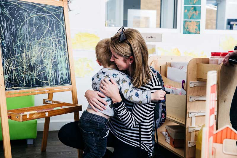 Child clings to mother. Clinginess and hiding behind family members is one of the signs of shy babies.