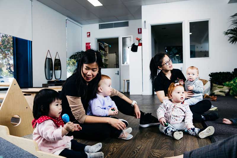 Babies sit around a studio with early childhood educators listening to music. Any baby can get cradle cap, it is a type of dermatitis that is not infectious.