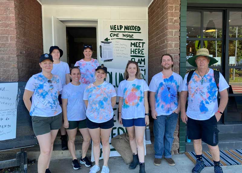 Karin with team members from Petit ELJ Murwillumbah stand outside a community volunteer centre ready to help with flooding cleanup demonstrating their adaptability and a focus on continual improvement.