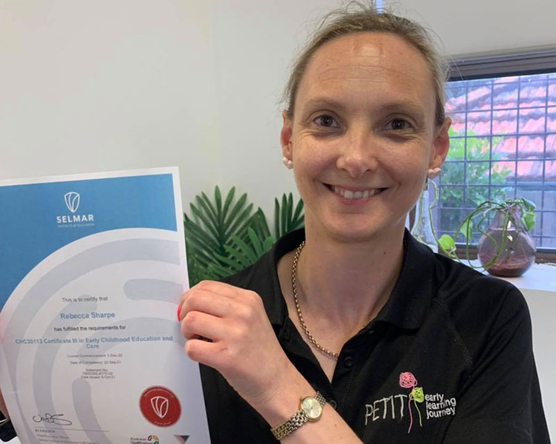 An Educator proudly displays her Cert III in Early Childhood Education and Care