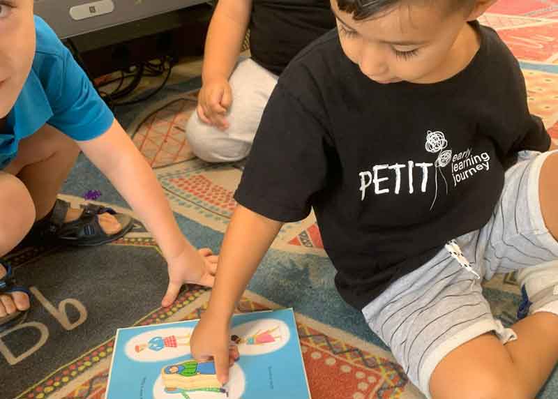  Children read a book and play while engaged in learning through kindergarten. 