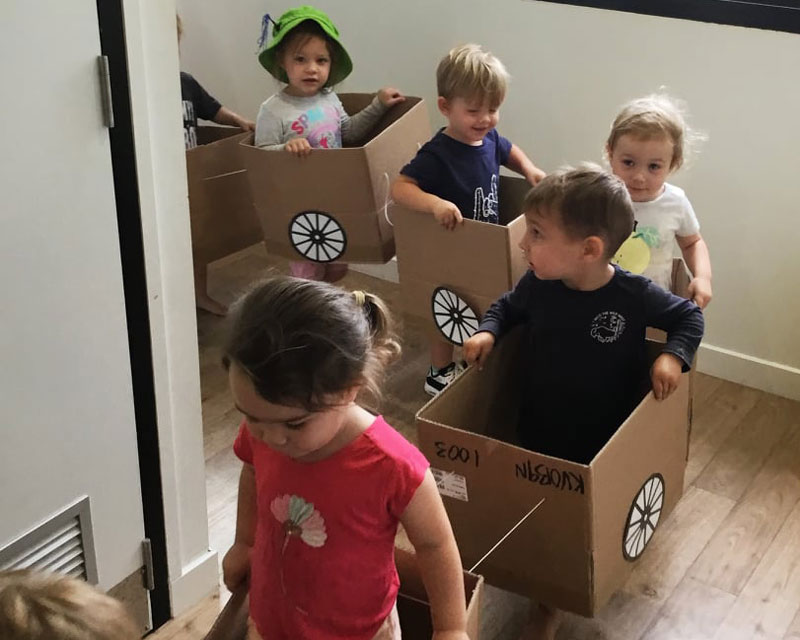 Children play with handmade cardboard toys at Petit Early Learning Journey.