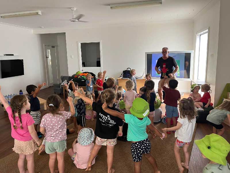 Australian indigenous author, Chris Collins dances with a large group of Petit Early Learning Journey children to introduce his children's book, Funky Chicken Crocs and Chooks. 