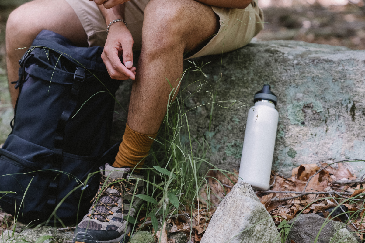 Stainless water bottle placed next to a man's legs