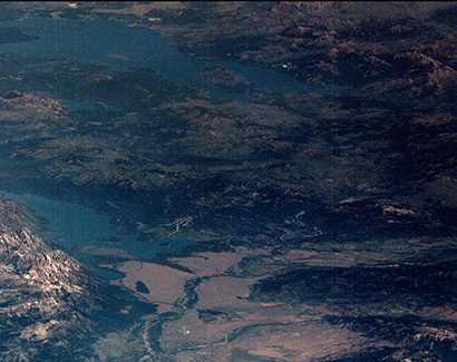 The Grand Tetons preside over the Snake River and Jackson Lake. The moon's shadow is visible to the East.