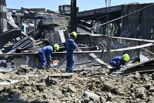 Des ouvriers travaillent dans les décombres du centre commercial Amstor, détruit par une frappe de missiles russes, le 28 juin 2022 à Krementchouk (Ukraine)