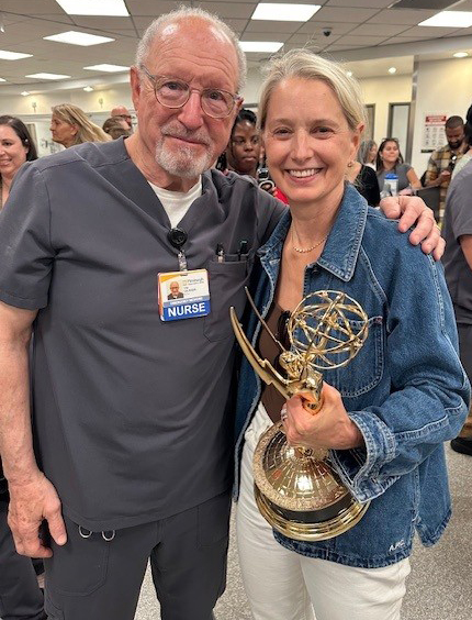 Tim Van Pelt standing with Katherine LaNasa who is holding an Emmy Award.