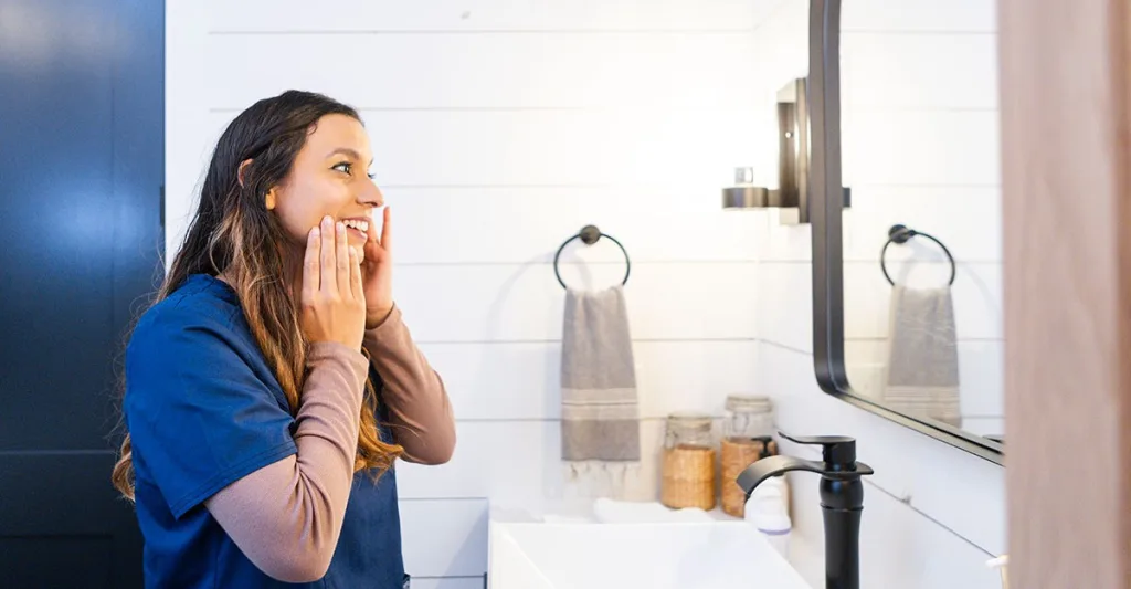 Nurse looking in a mirror, practicing self-compassion