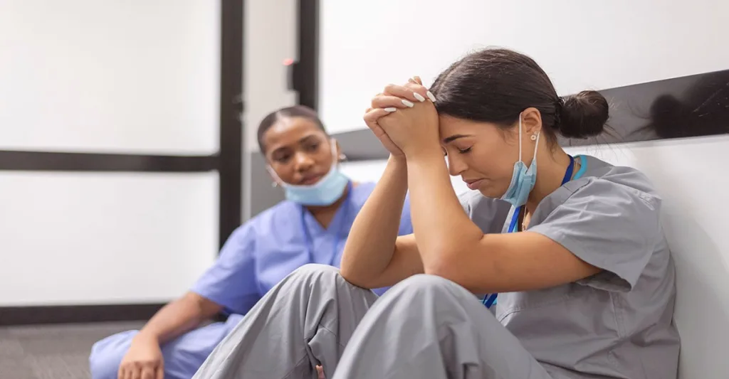 stressed nurses sitting on the floor