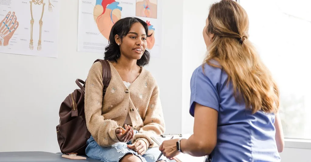 Nurse talking with patient collecting subjective and objective nursing data