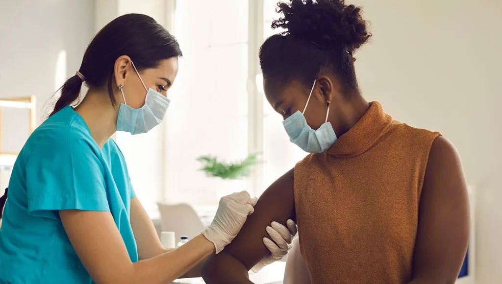 Public health nurse giving vaccine to a patient